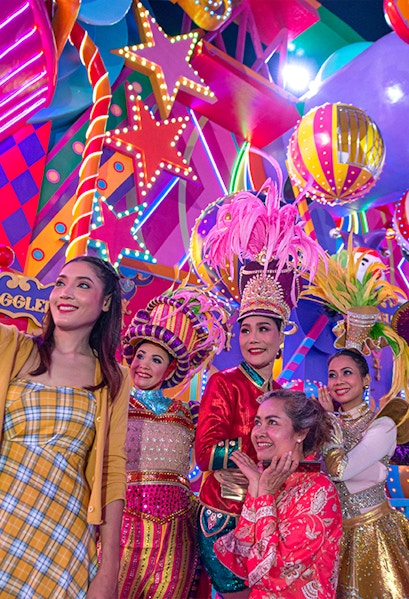 Performers in colorful costumes at Carnival Magic Park Phuket.