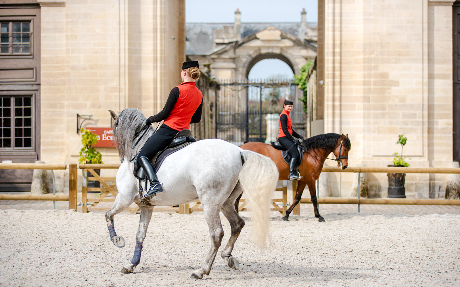 Equestrian show at Chateau of Chantilly with riders performing in front of historic architecture.