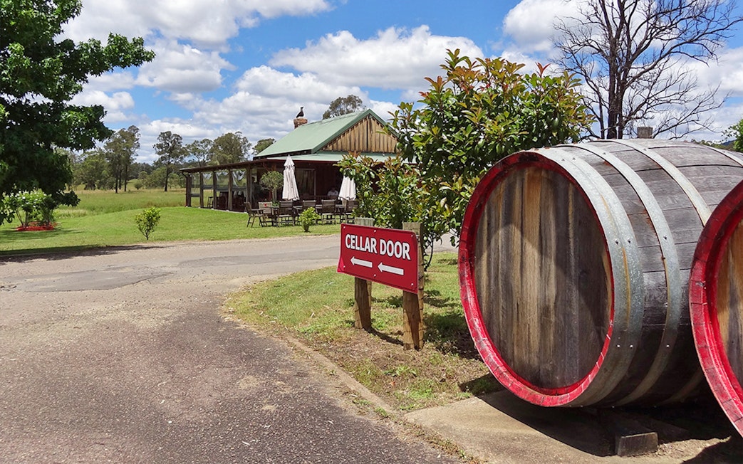 Cellar door sign and wine barrels at a vineyard in Hunter Valley.