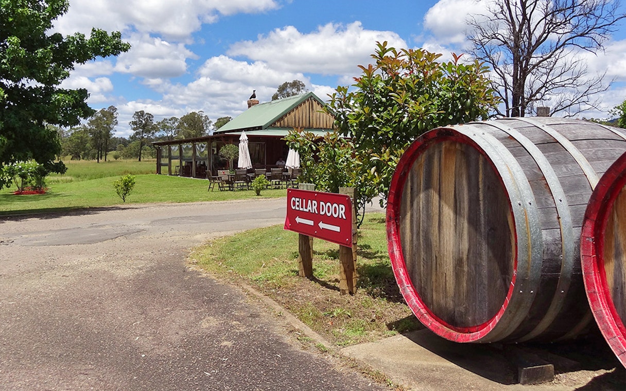 Cellar door sign and wine barrels at a vineyard in Hunter Valley.