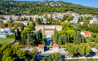 Aerial view of Split with historic architecture and lush greenery, highlighting Diocletian's Palace area.