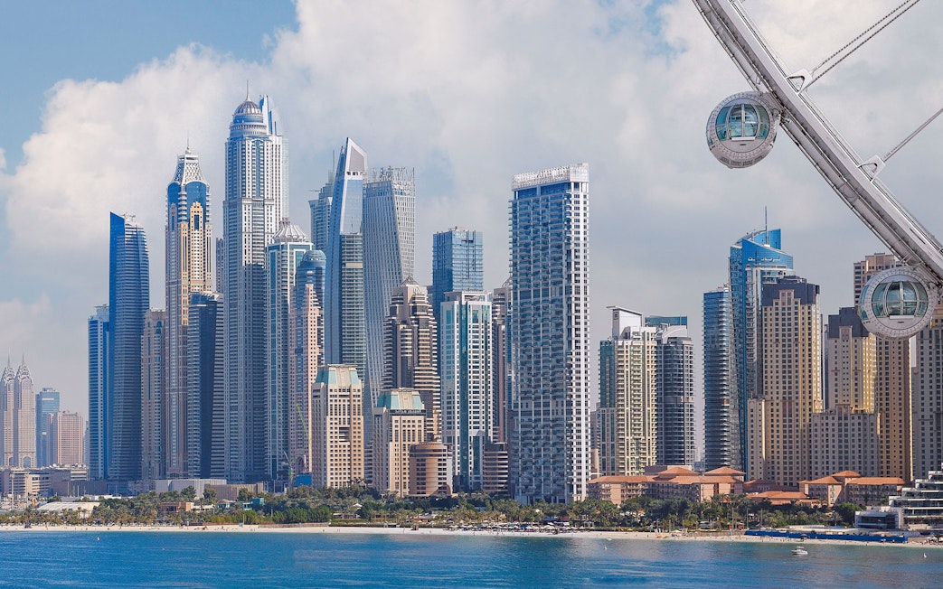 Ain Dubai pods overlooking Dubai Marina skyline.