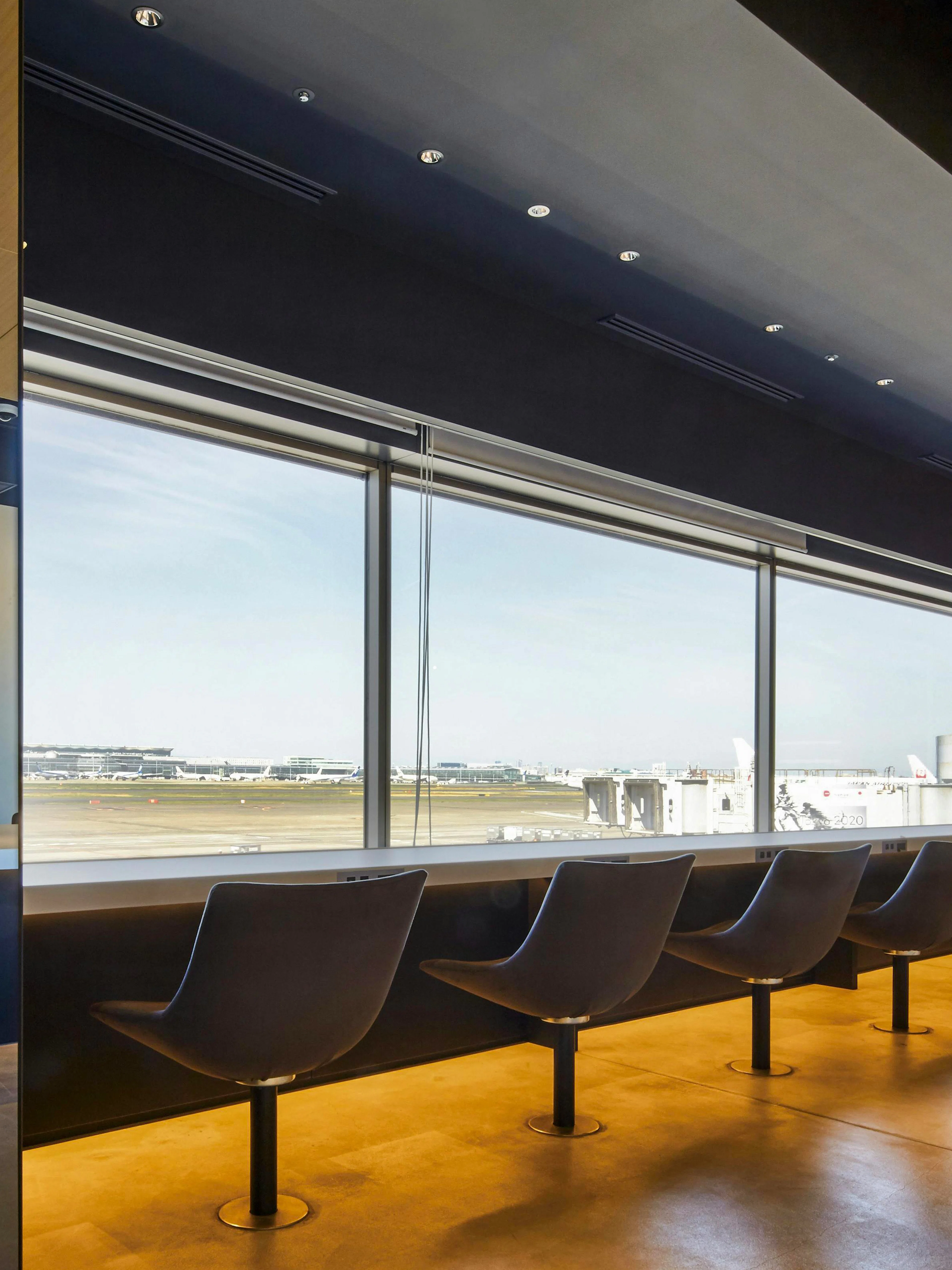 Seating area with runway view at POWER LOUNGE SOUTH, Tokyo International Airport.