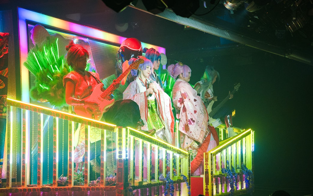 Performers in colorful costumes on stage at Samurai Restaurant Show, Tokyo.