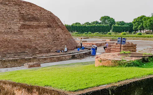 Ancient brick structure with workers at Varanasi archaeological site, India.