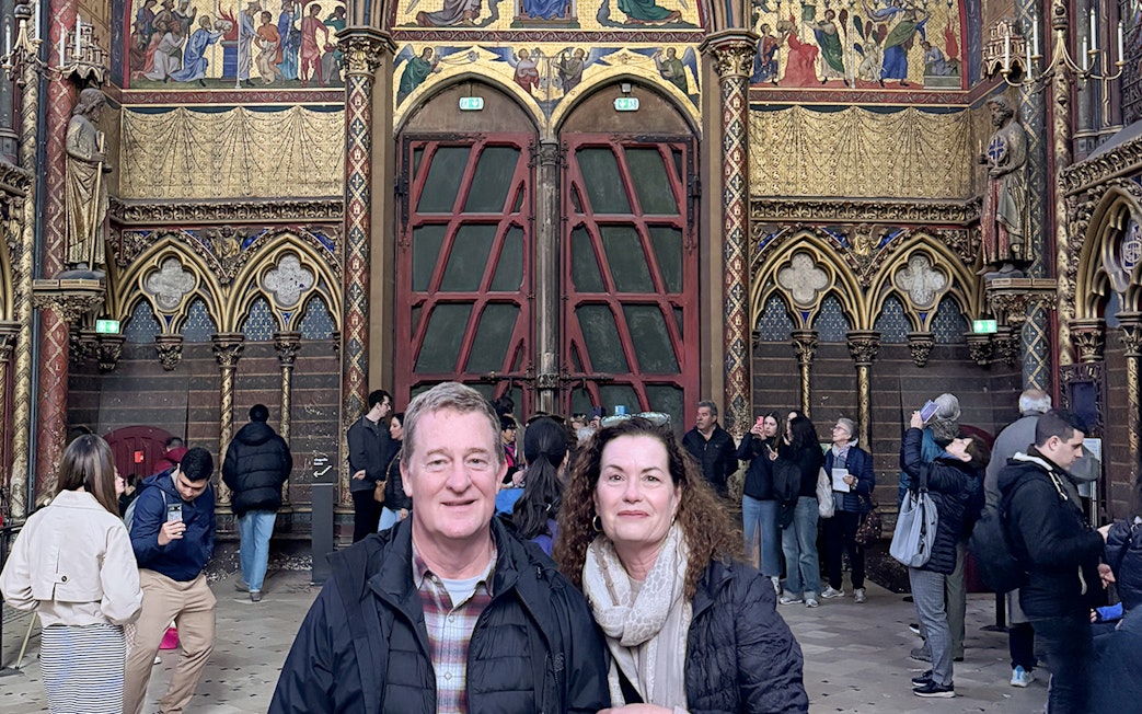 Visitors inside Sainte Chapelle, Paris, admiring the ornate interior and stained glass.