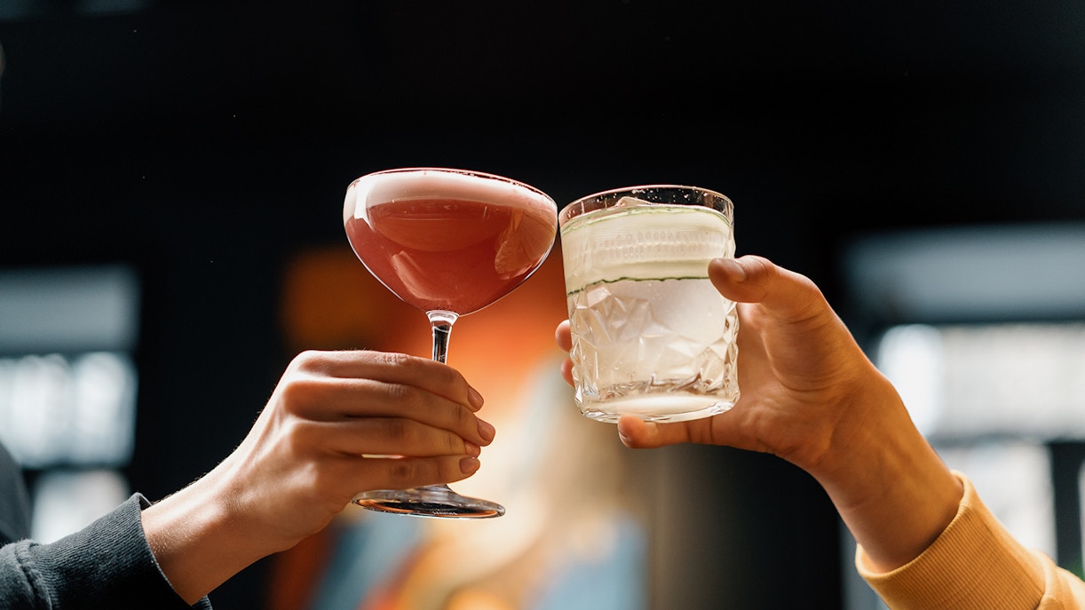 Two people clinking cocktail glasses