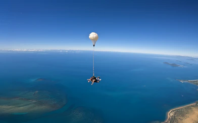 Tandem skydive over Cairns with view of ocean and coastline.
