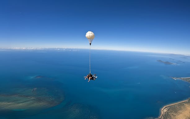 Tandem skydive over Cairns with view of ocean and coastline.