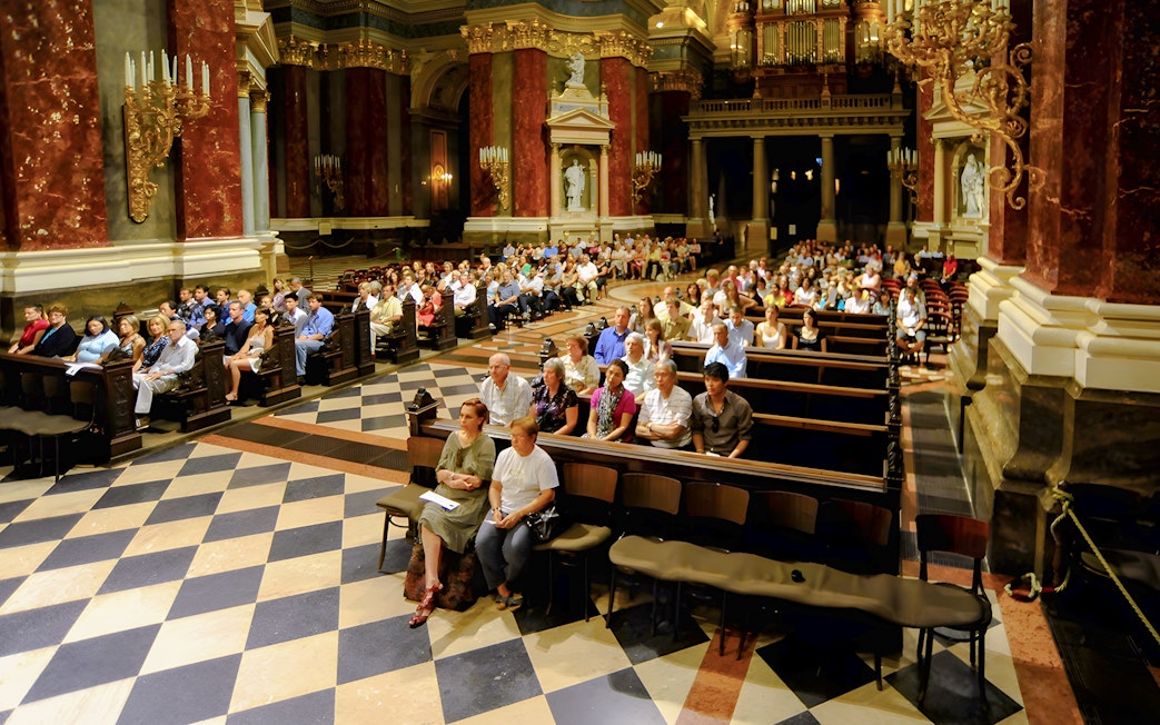 Guests seated in St. Stephen's Basilica for a live organ concert in Budapest.
