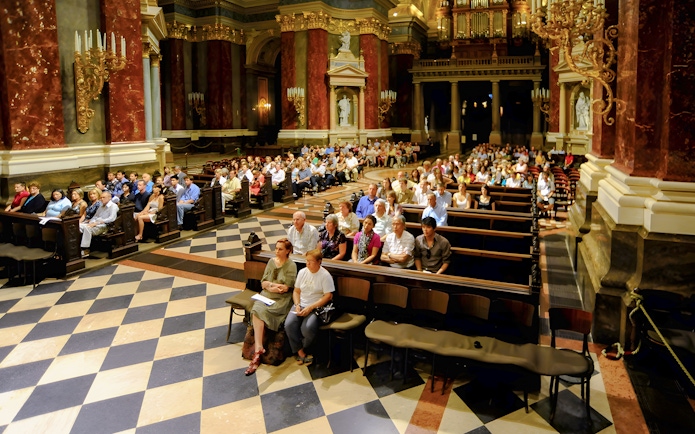Guests seated in St. Stephen's Basilica for a live organ concert in Budapest.