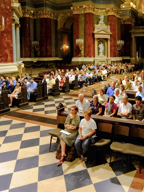 Guests seated in St. Stephen's Basilica for a live organ concert in Budapest.