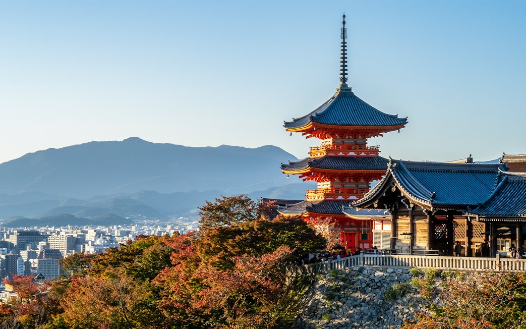 Kiyomizu-dera Temple with autumn foliage and cityscape in Kyoto, Japan.