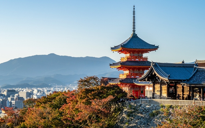 Kiyomizu-dera Temple with autumn foliage and cityscape in Kyoto, Japan.