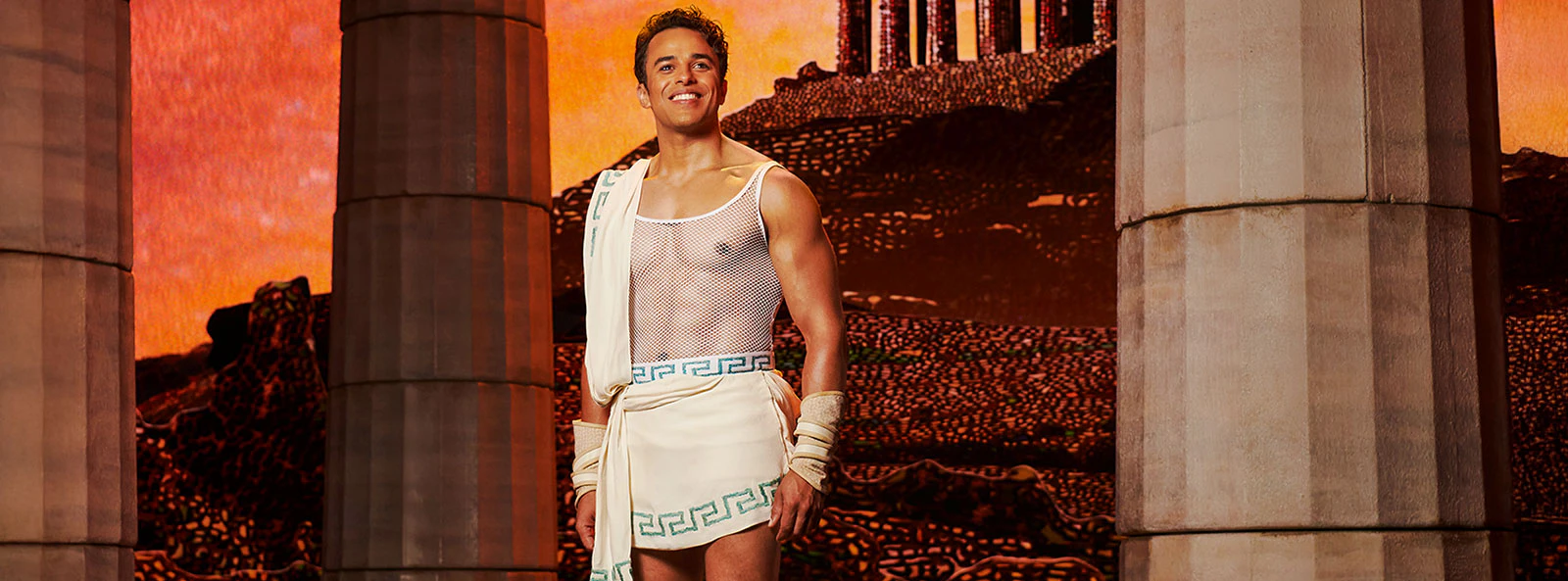 Man in ancient Greek attire stands between columns, representing Disney's Hercules.