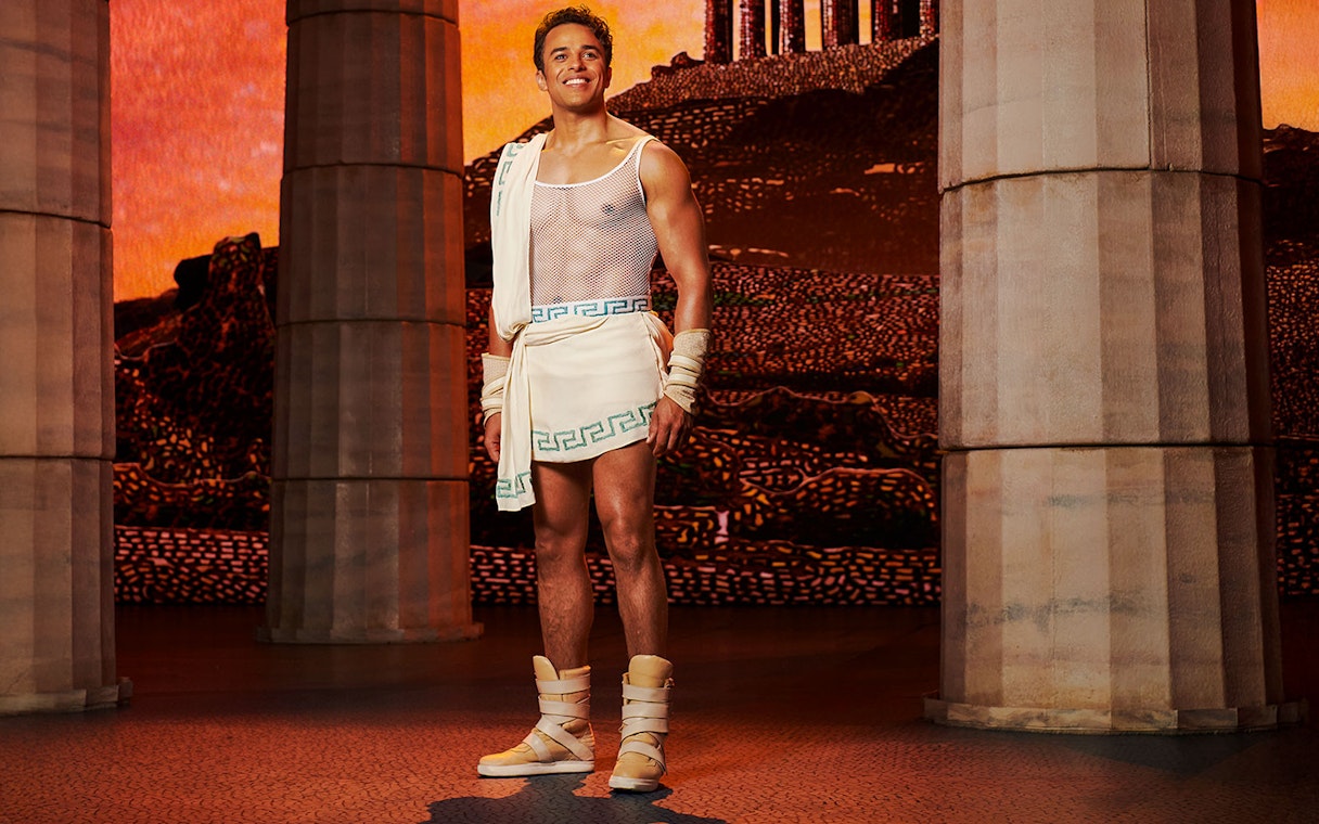 Man in ancient Greek attire stands between columns, representing Disney's Hercules.