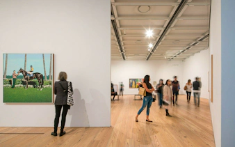 Visitors viewing art exhibits at Whitney Museum in New York City.