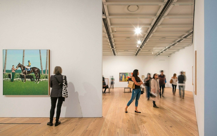 Visitors viewing art exhibits at Whitney Museum in New York City.
