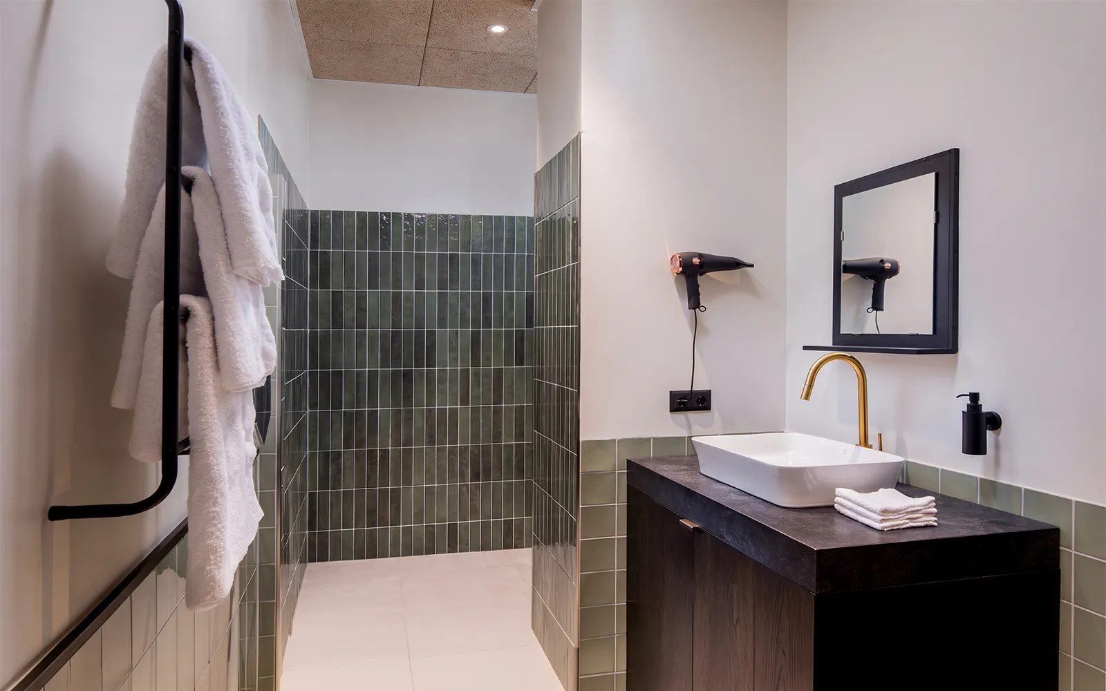 Aspire Lounge bathroom with towels, sink, and hairdryer at Copenhagen Kastrup Airport Terminal 2.