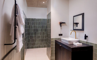 Aspire Lounge bathroom with towels, sink, and hairdryer at Copenhagen Kastrup Airport Terminal 2.
