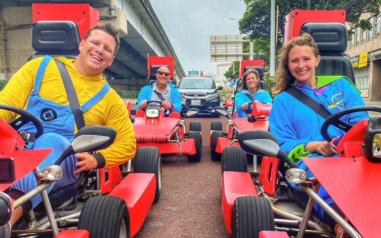 Street go-karting group in colorful costumes driving through Okinawa.