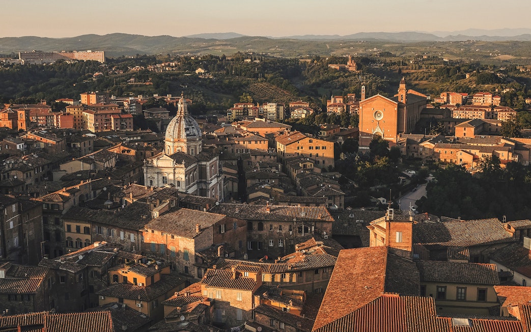 Aerial view of Siena's historic rooftops and cathedral in Tuscany, Italy.