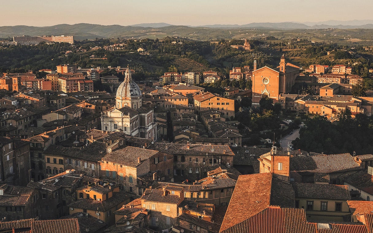 Aerial view of Siena's historic rooftops and cathedral in Tuscany, Italy.