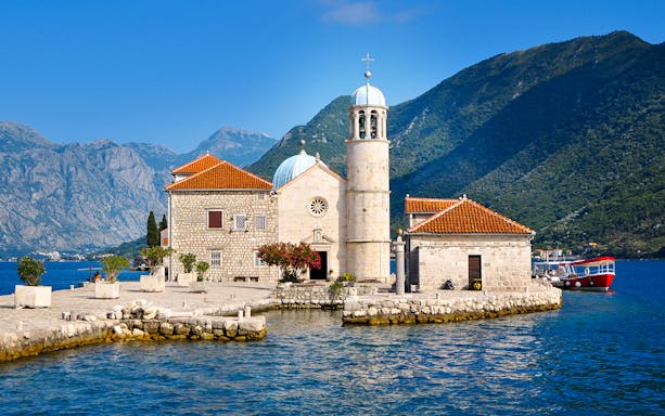 Our Lady of The Rocks island with church and mountains in Kotor Bay, Montenegro.
