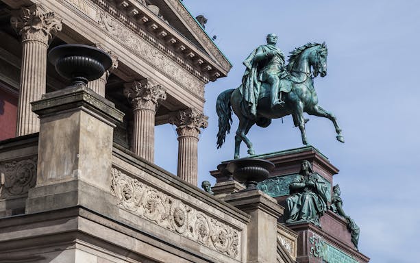 Equestrian statue and ornate facade of Alte Nationalgalerie, Berlin.