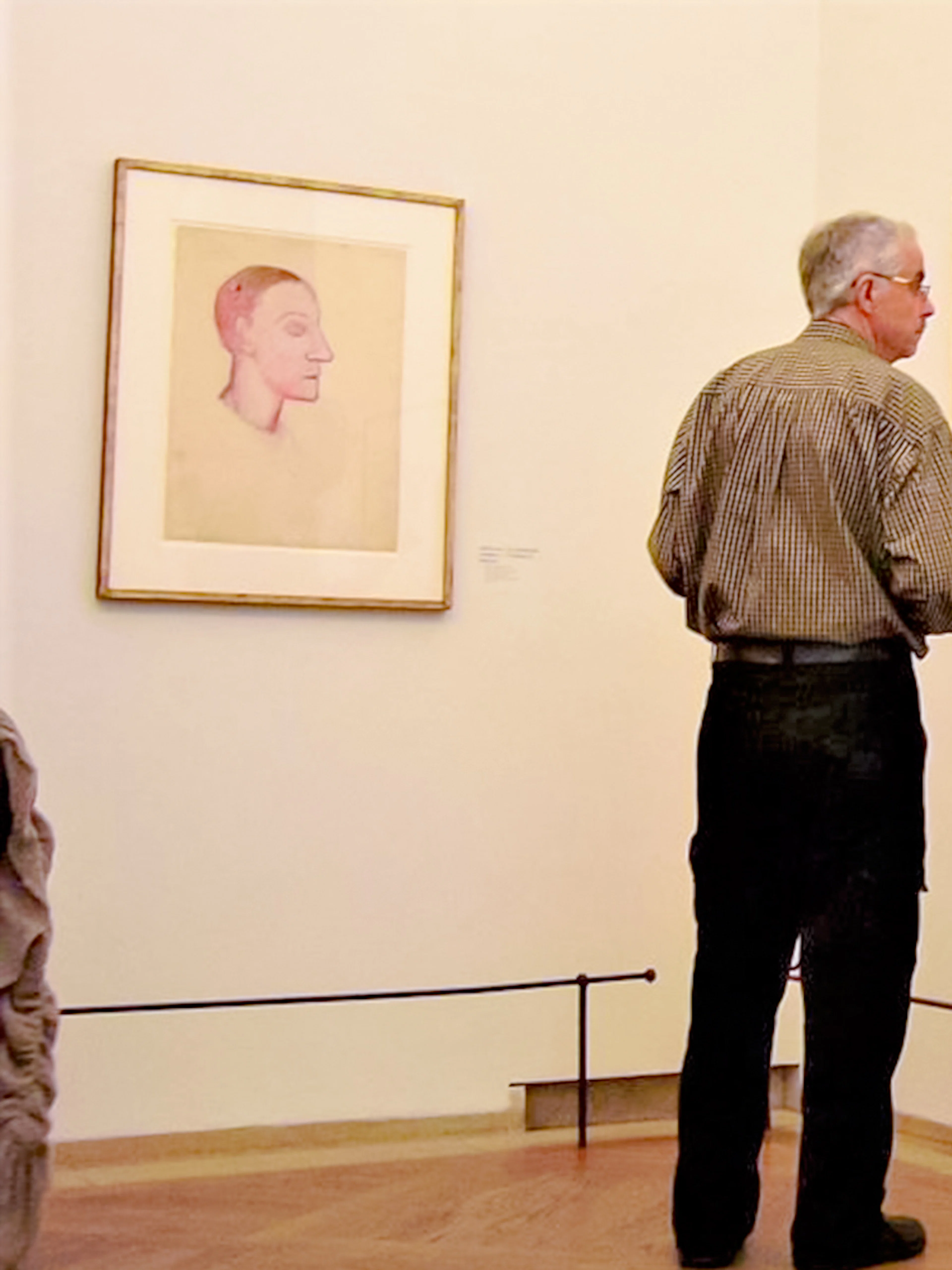 Man observing Picasso sketches at Picasso Museum.