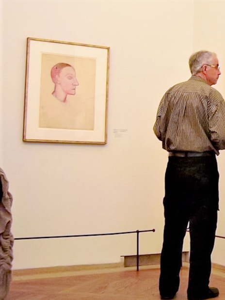 Man observing Picasso sketches at Picasso Museum.