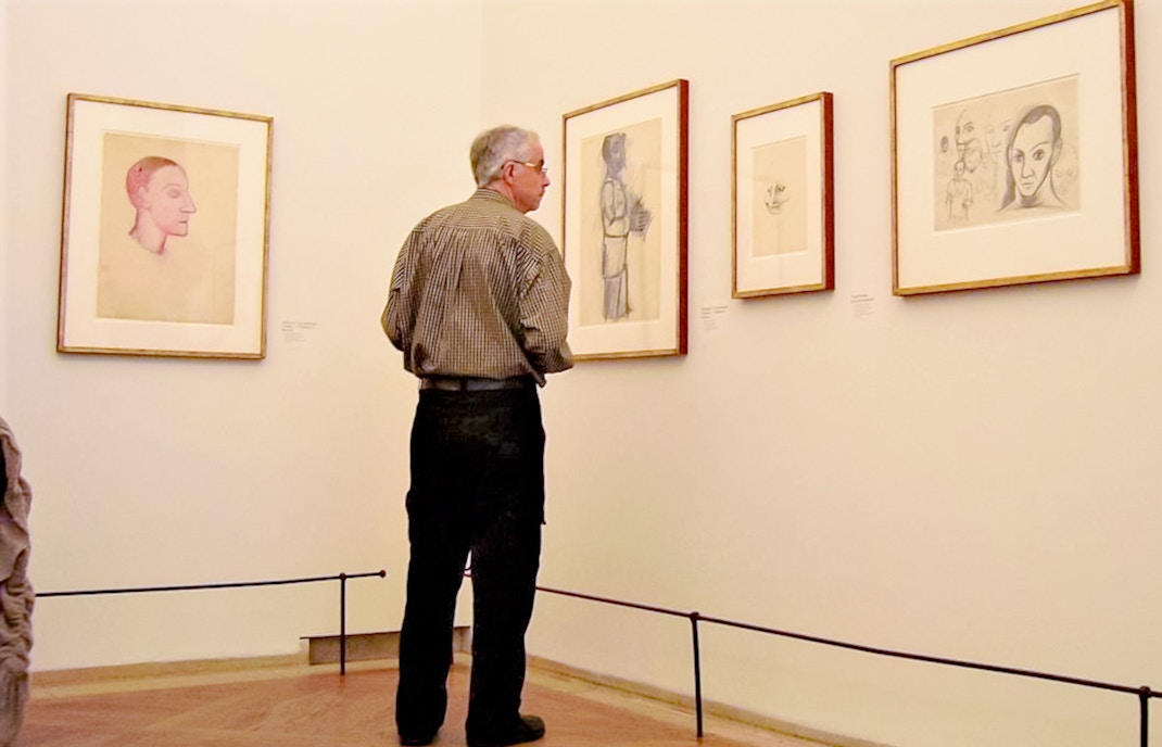 Visitor observing artwork inside Picasso Museum, Barcelona.