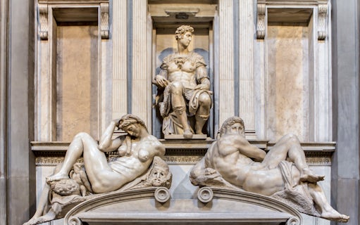 Medici Chapel sculptures in Florence, featuring reclining figures and seated statue.