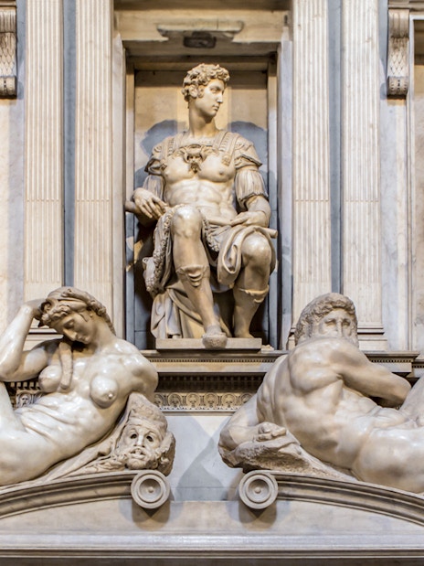 Medici Chapel sculptures in Florence, featuring reclining figures and seated statue.