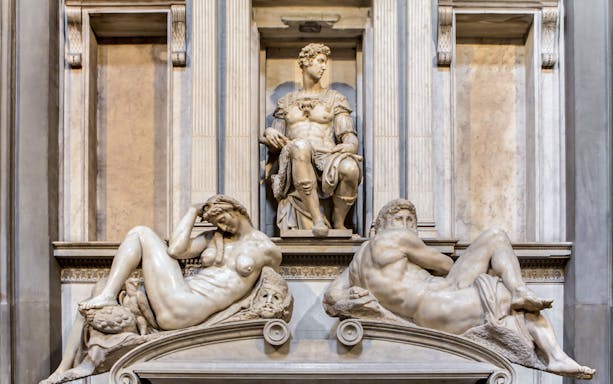 Medici Chapel sculptures in Florence, featuring reclining figures and seated statue.