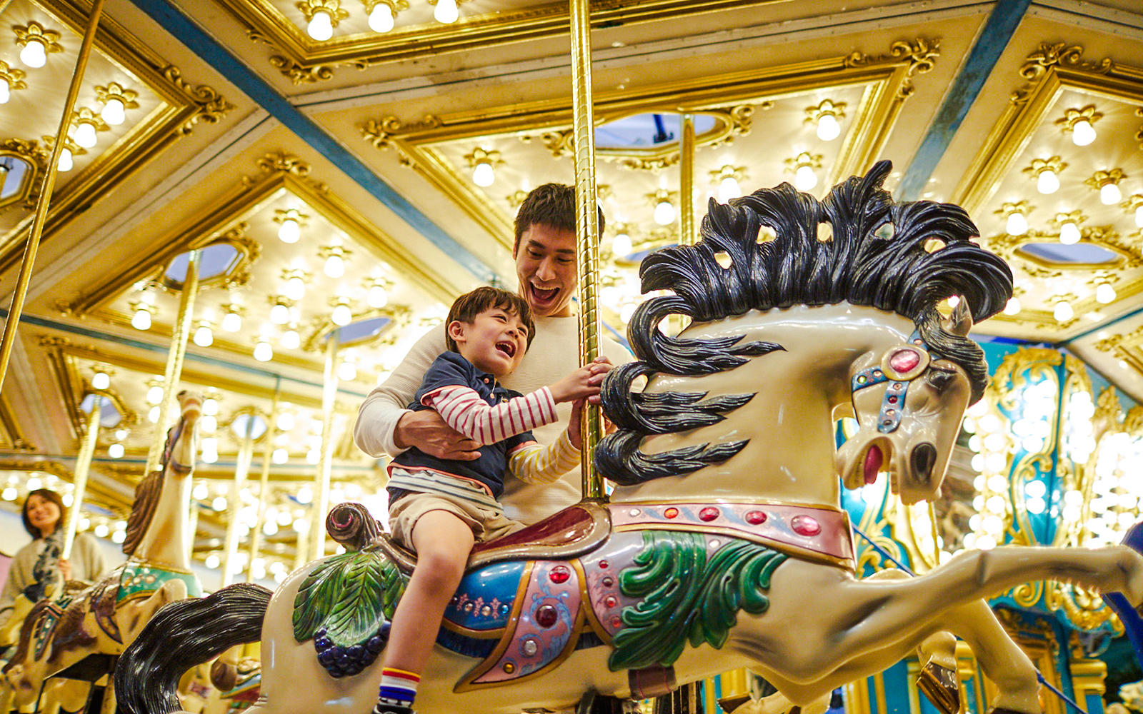 Father and child enjoying a carousel ride at Ocean Park Hong Kong.