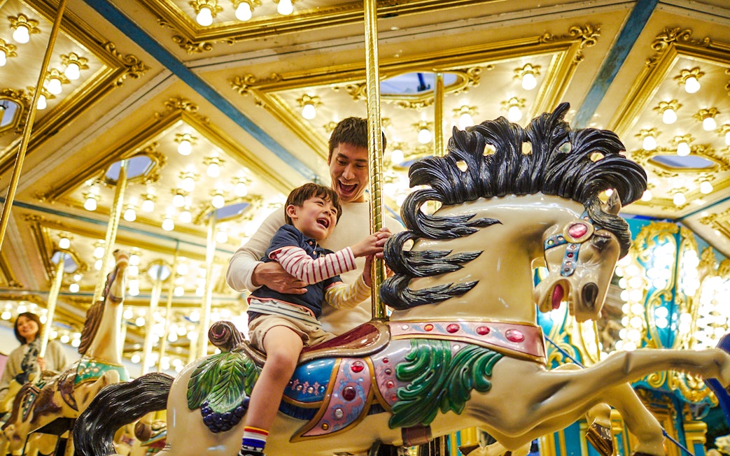 Father and child enjoying a carousel ride at Ocean Park Hong Kong.
