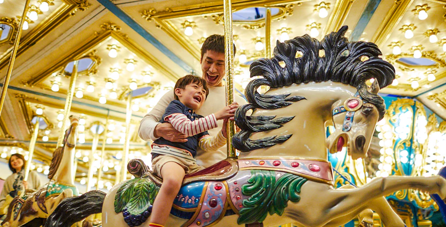 Father and child enjoying a carousel ride at Ocean Park Hong Kong.