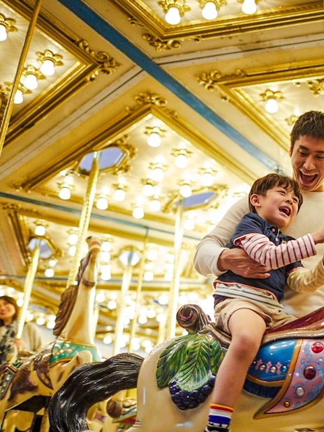 Father and child enjoying a carousel ride at Ocean Park Hong Kong.