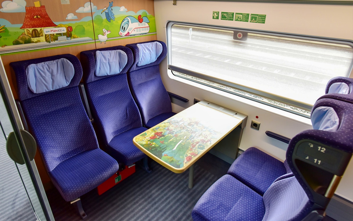 Train compartment with four blue seats and a table, part of Interrail Germany Mobile Pass Flex - 2nd Class.