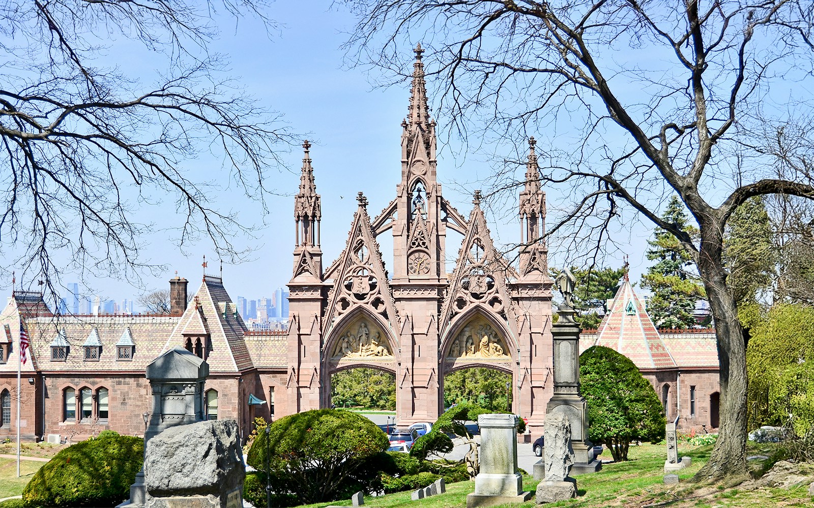 Gothic entrance of Green-Wood Cemetery in Brooklyn, NY with historic gravestones and trees.