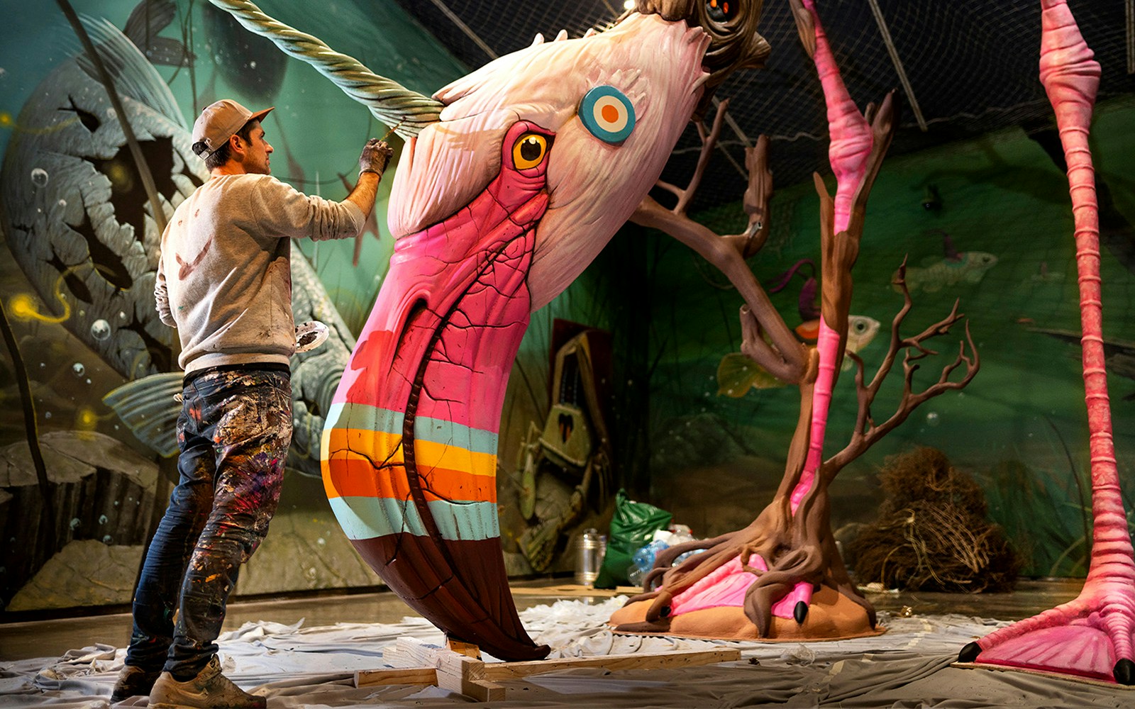 Artist painting colorful sculpture at STRAAT Museum in Amsterdam.