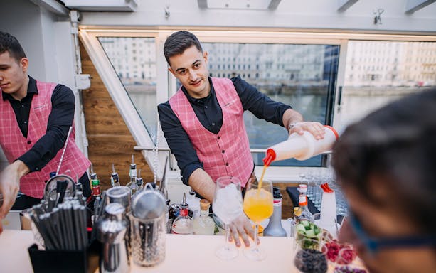 Bartender preparing cocktails on New Year's Eve dinner cruise.