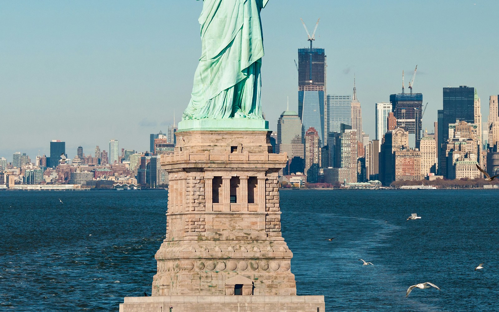 Statue of Liberty pedestal with New York City skyline in the background.
