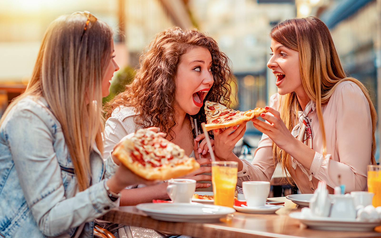 3 girls enjoying Italian pizza in restaurant
