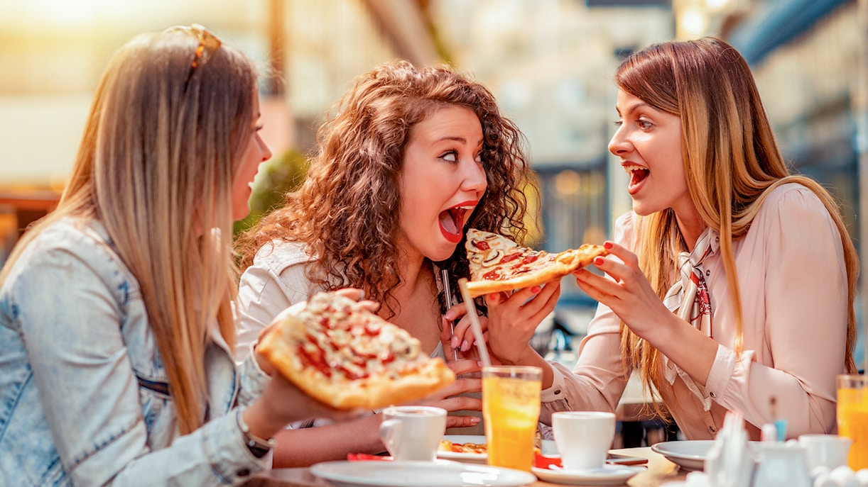 3 girls enjoying Italian pizza in restaurant