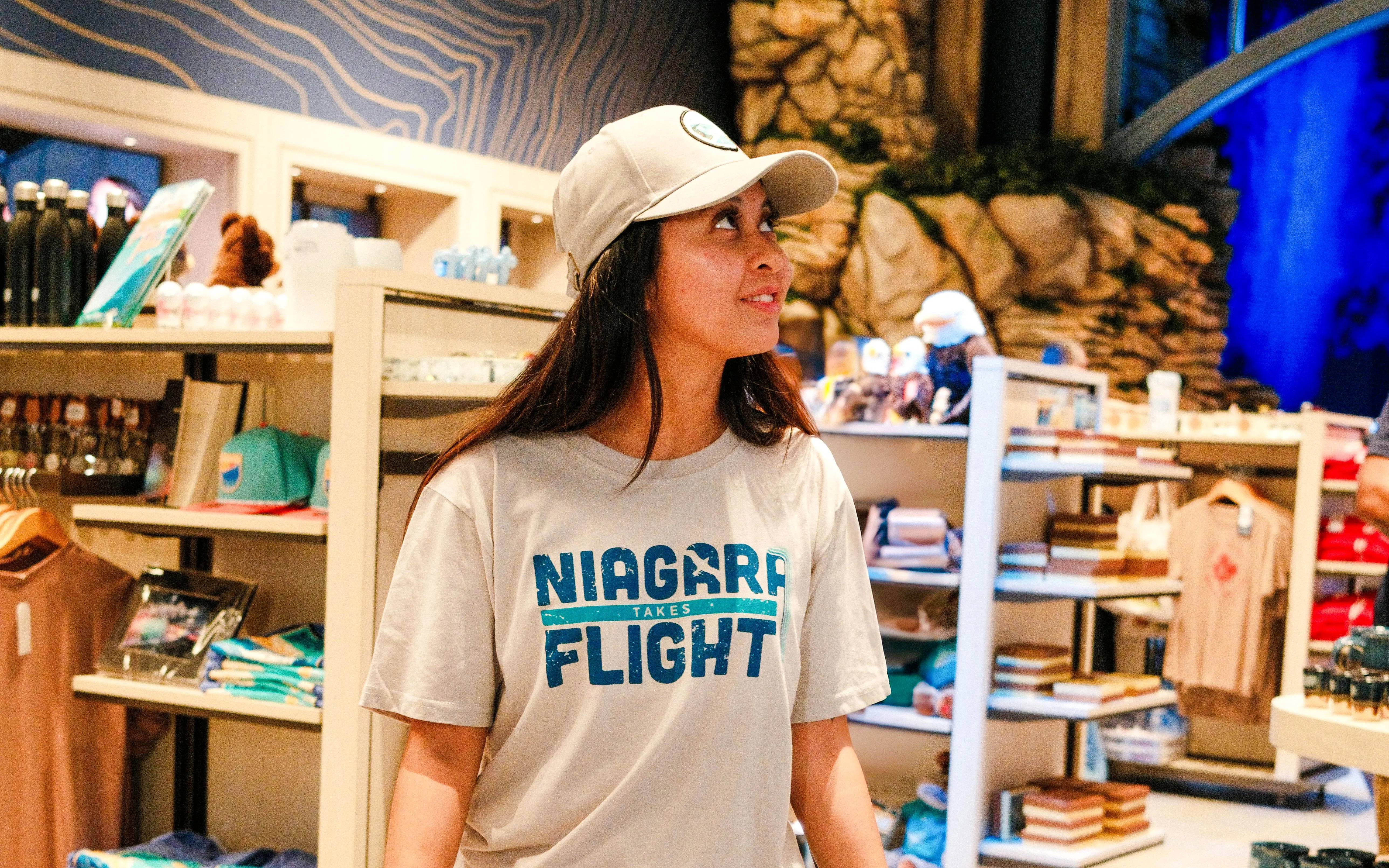 Person wearing "Niagara Takes Flight" shirt in a souvenir shop, Canada.