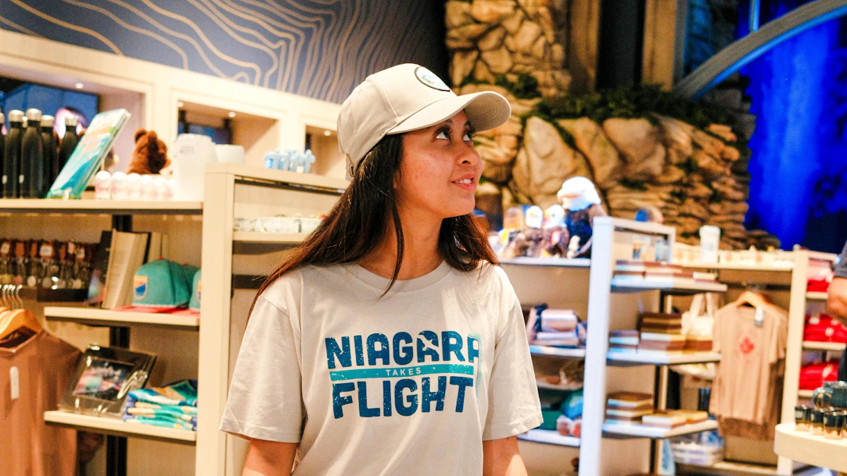 Person wearing "Niagara Takes Flight" shirt in a souvenir shop, Canada.