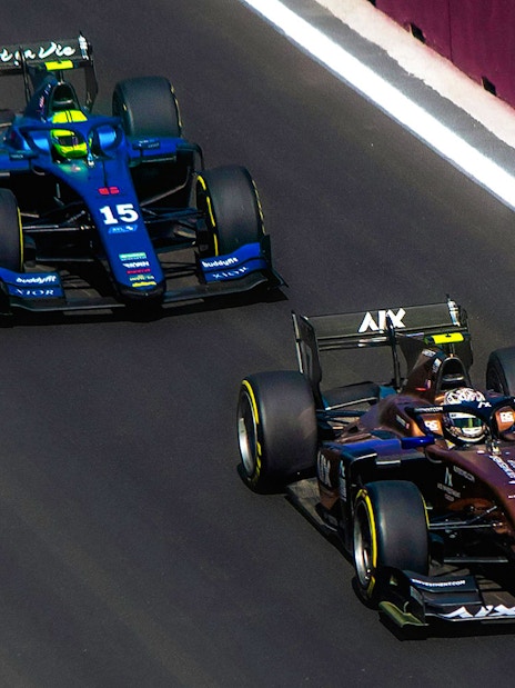 Two Formula 1 cars racing on a track in Qatar.