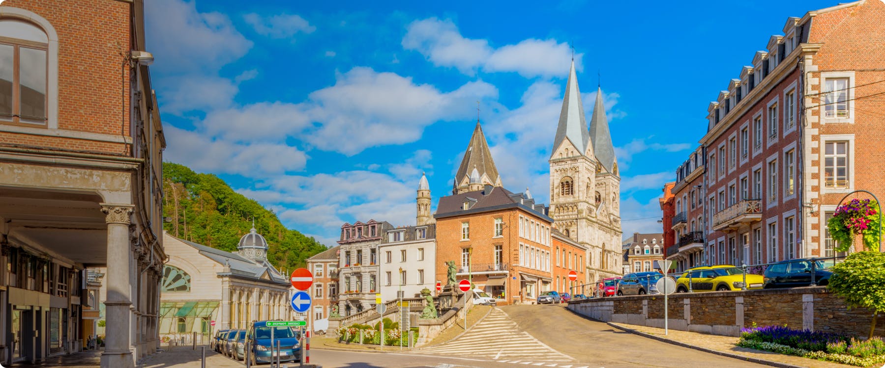Street view of Spa, Belgium with historic buildings and church towers.
